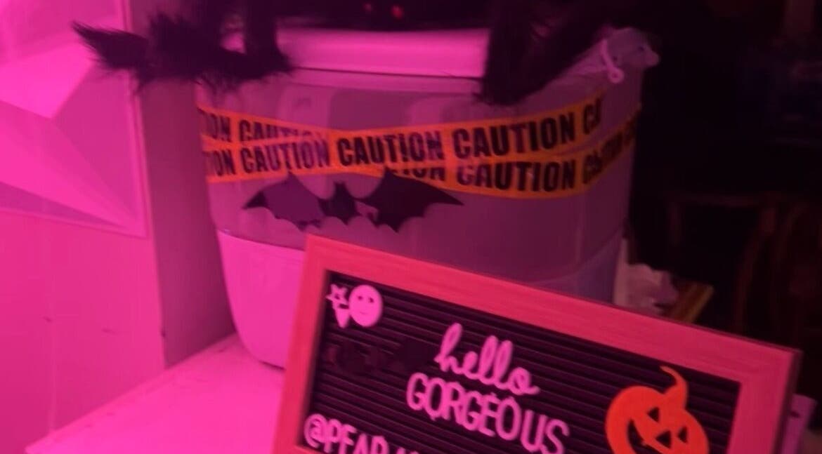 Halloween decor at PEARADISE, Baltimore, Maryland, US, featuring caution tape and a 'hello gorgeous' sign.