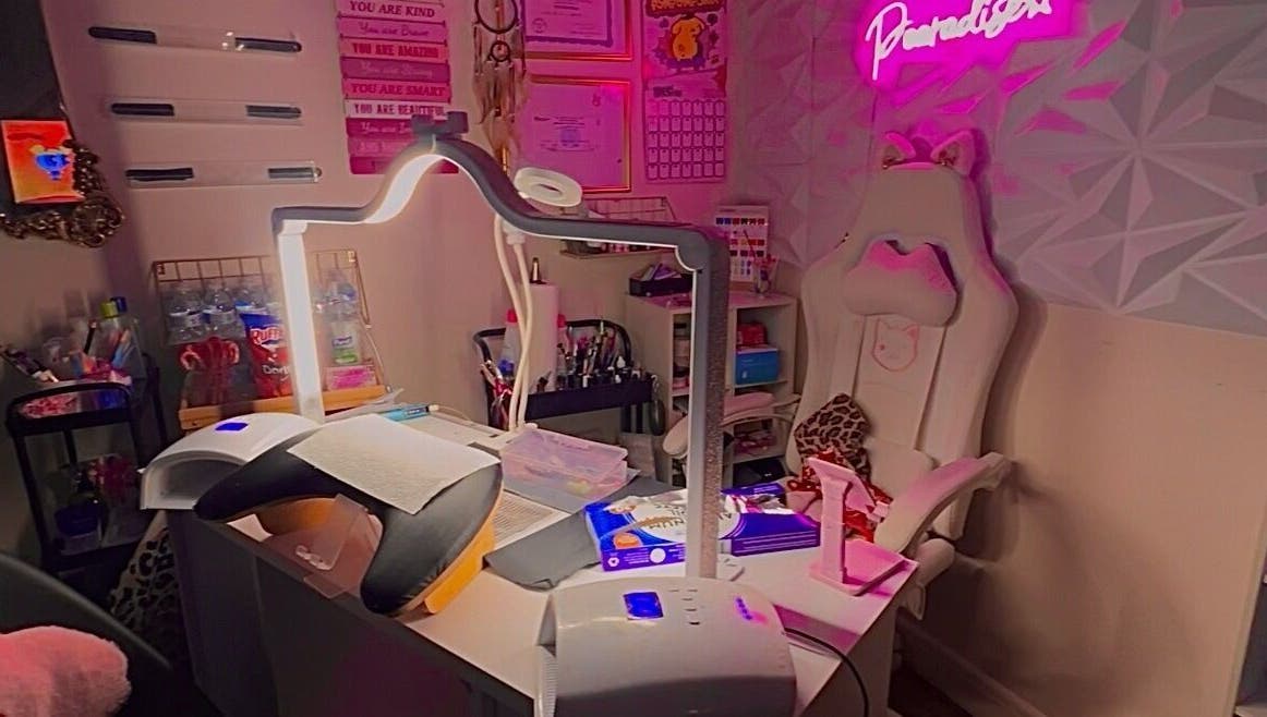 A cozy beauty space in Pearadise, Baltimore, Maryland, US, with a well-equipped manicure station and pink decor.