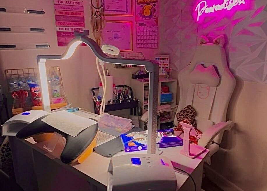 A cozy beauty space in Pearadise, Baltimore, Maryland, US, with a well-equipped manicure station and pink decor.