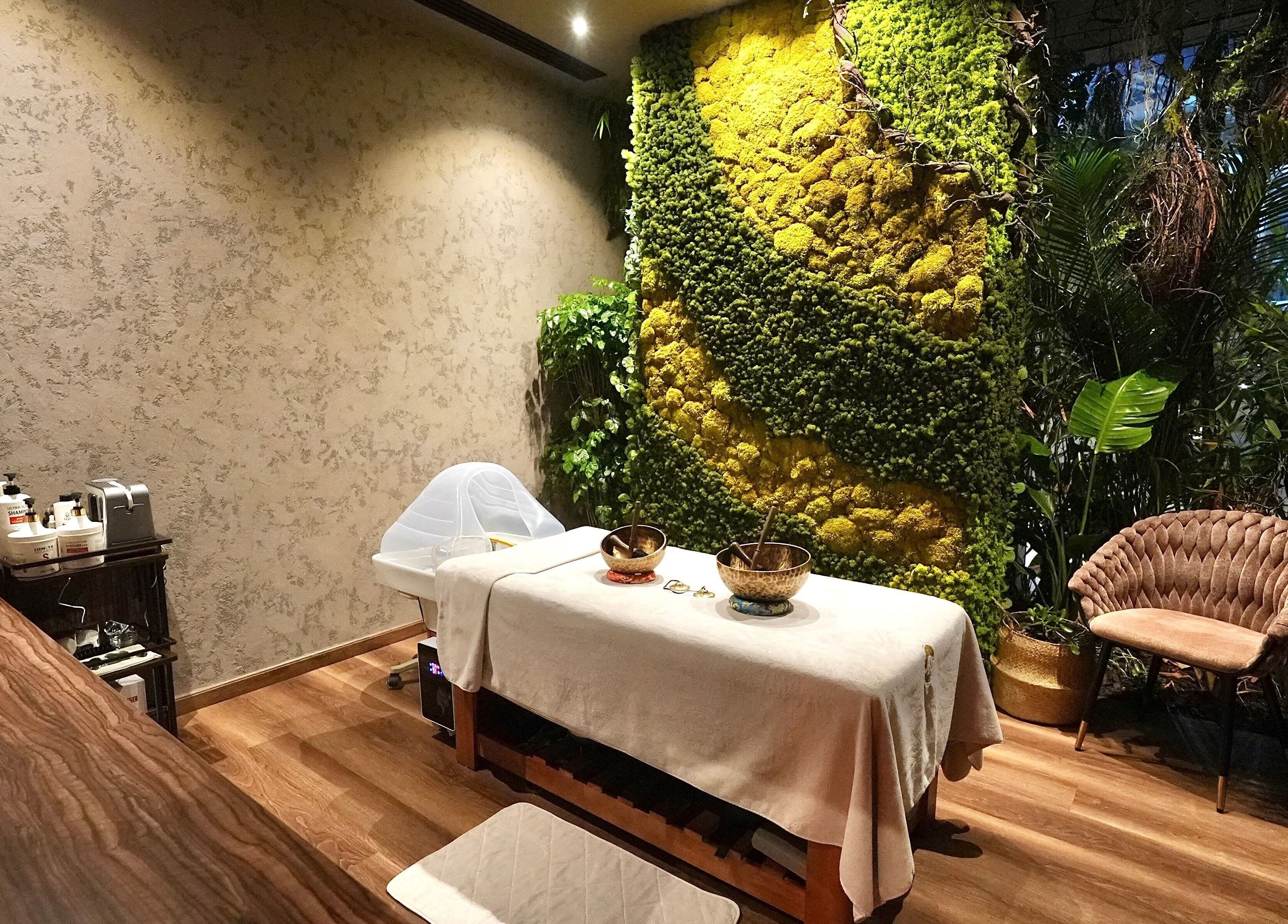 Serene treatment room at Adara Spa Retreat, Ladies Spa, Dubai, Dubai, AE, featuring lush greenery and cozy seating.