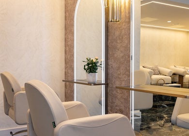 Modern salon interior at George Vallossian, London, England, GB, featuring stylish chairs and mirrors.