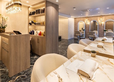 Luxurious interior of George Vallossian salon in London, England, GB showcasing marble decor and plush seating.