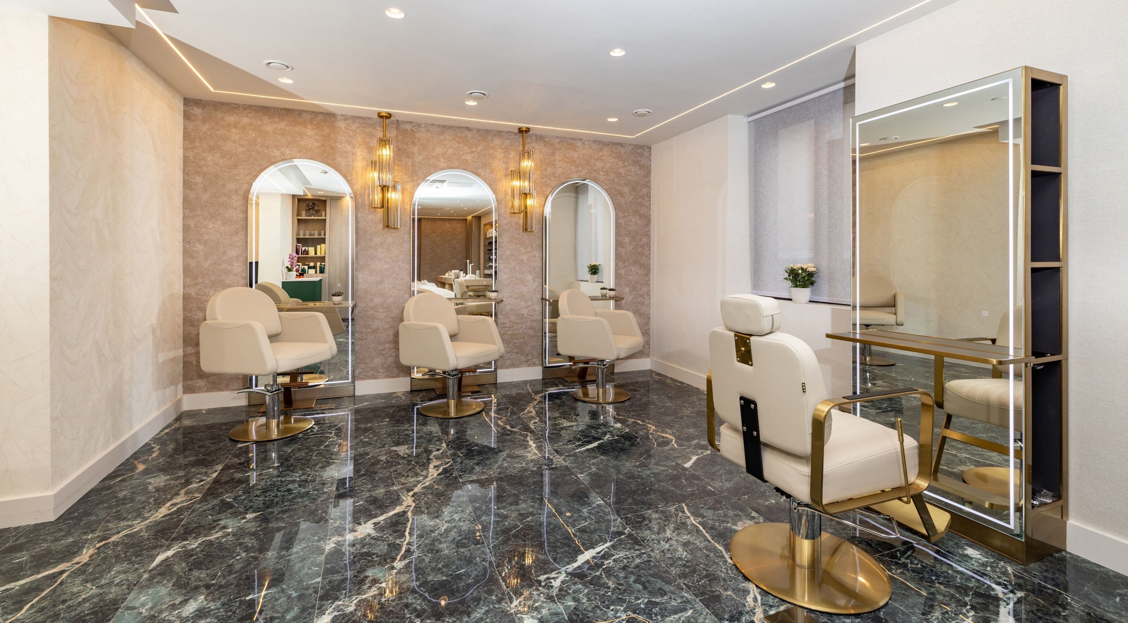 Stylish interior of George Vallossian beauty salon in London, England, GB showcasing modern seating and mirrors.