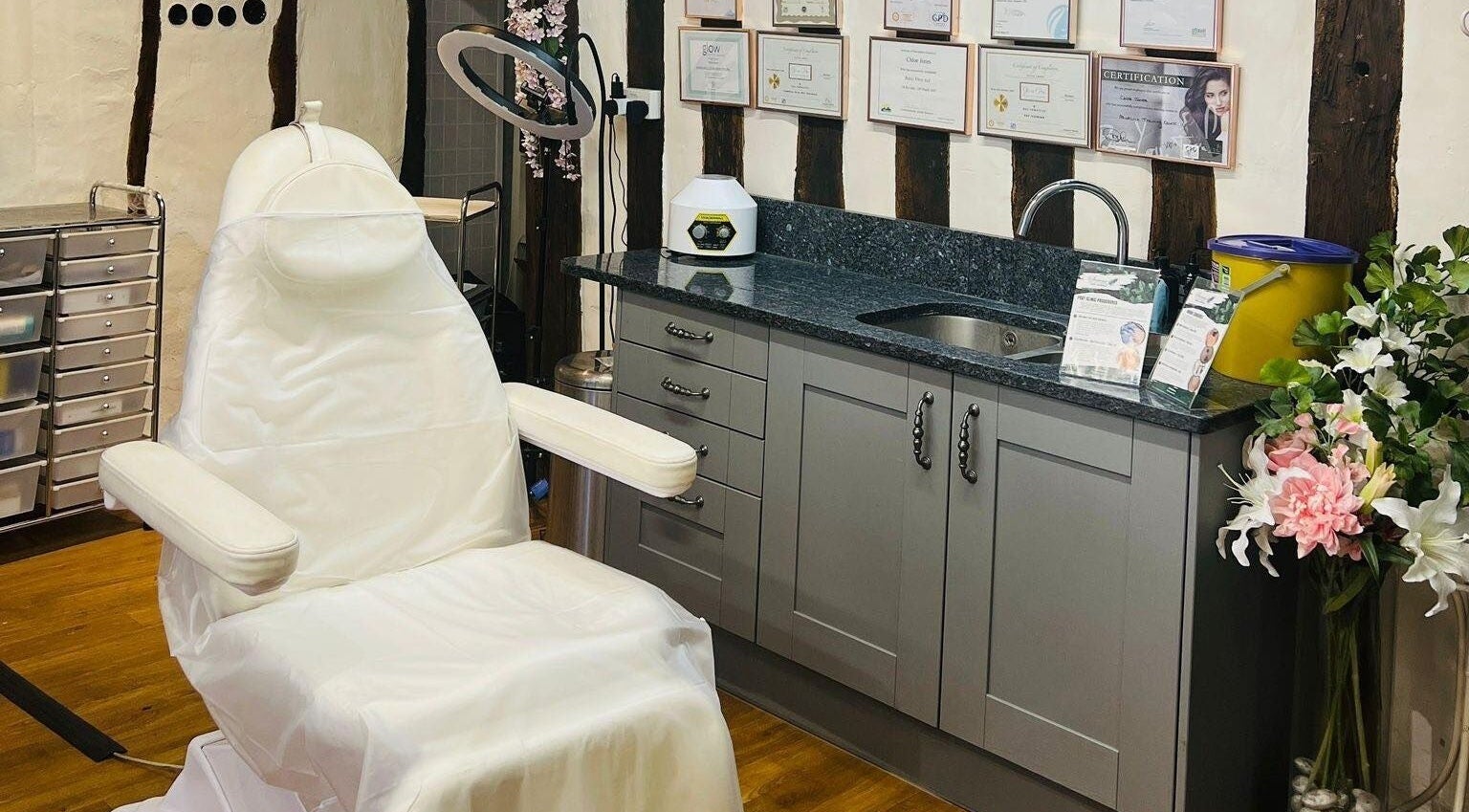 Serene treatment room at Skin & Vain in Lawford, England, GB, showcasing a white chair and certificates.