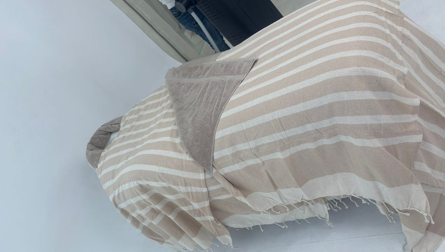 Relaxing treatment bed at Chemist Aesthetics Liverpool, Liverpool, England, GB, covered with striped linens.