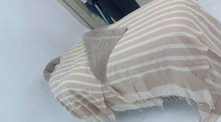 Relaxing treatment bed at Chemist Aesthetics Liverpool, Liverpool, England, GB, covered with striped linens.
