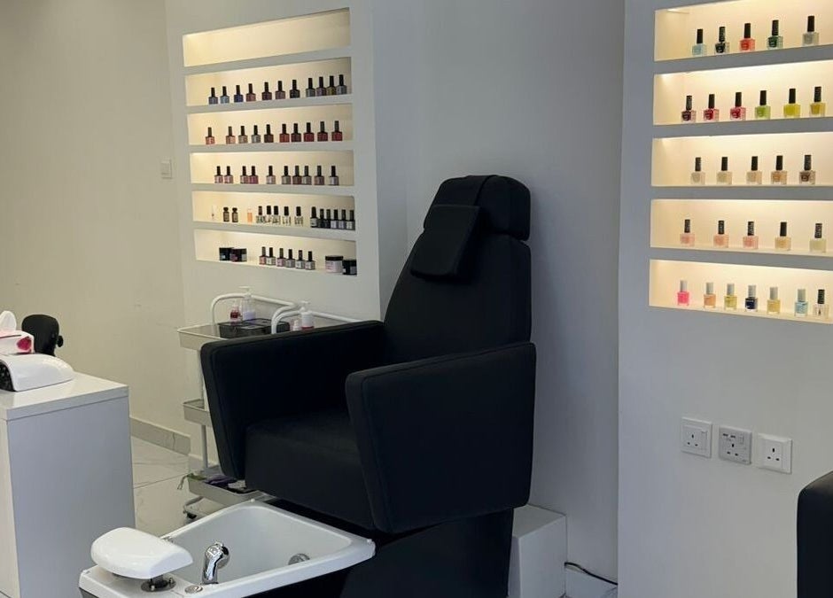 Nail care station at Nails on Wheels in الرياض, منطقة الرياض, SA featuring a plush chair and stylish polish display.