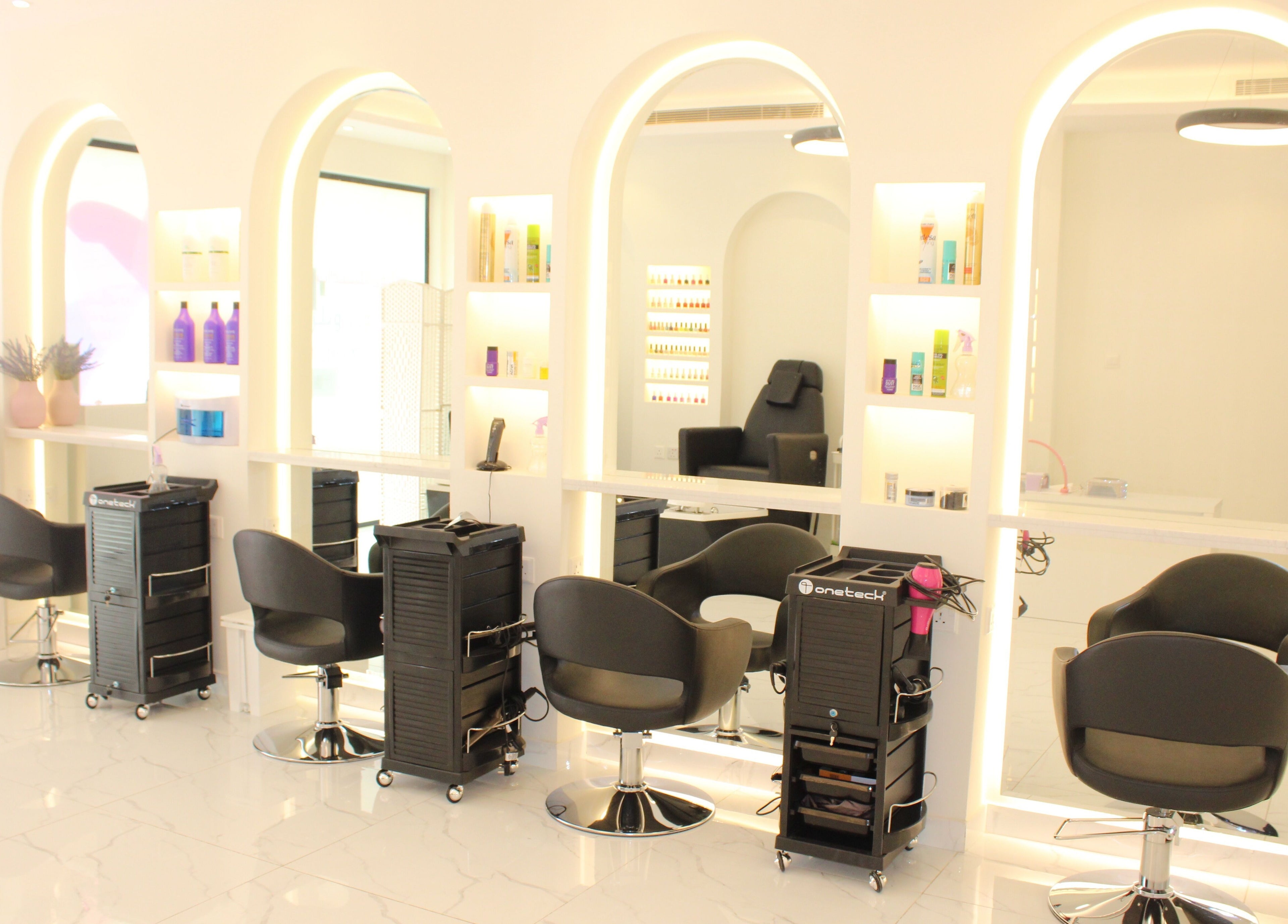 Elegant salon setup at Nails on Wheels, الرياض, منطقة الرياض, SA, featuring plush chairs and lit mirrors.