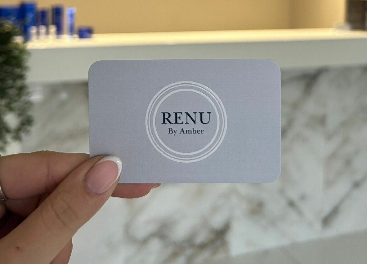 Hand holding RENU By Amber card at Bamber Bridge, England reception desk.