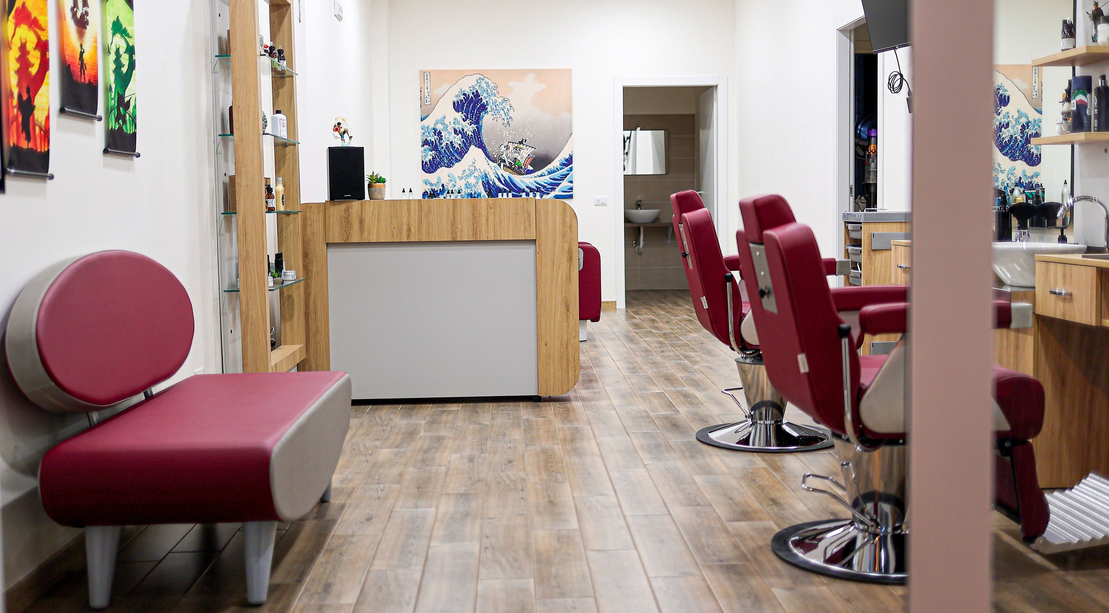 Interno di Barber Pole a Vittoria, Sicilia, IT con sedie rosse e decorazioni moderne.