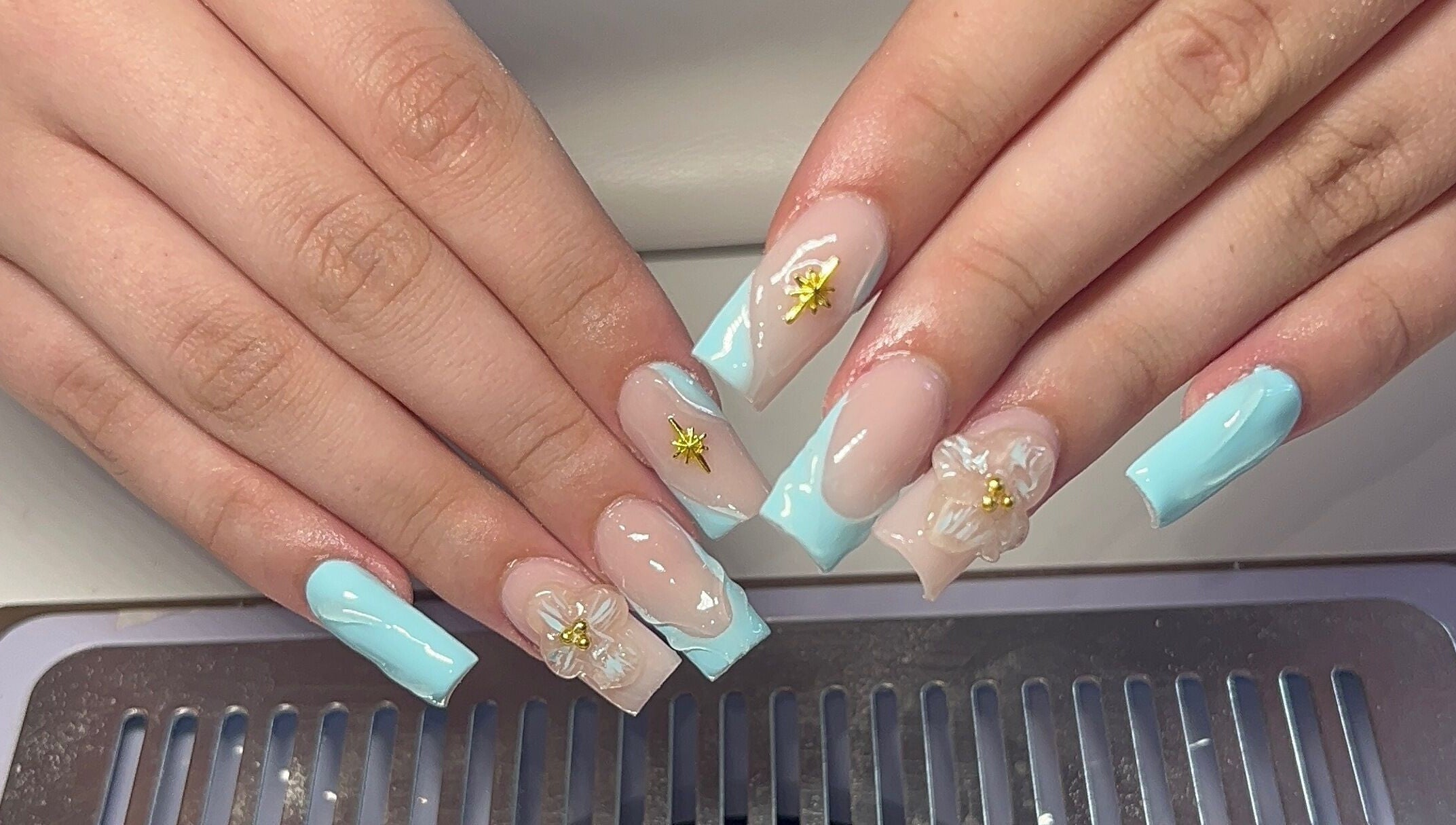 Intricate floral nail art at Beauty By Hannah in Moorside, England, GB, showcasing elegant blue and gold details.