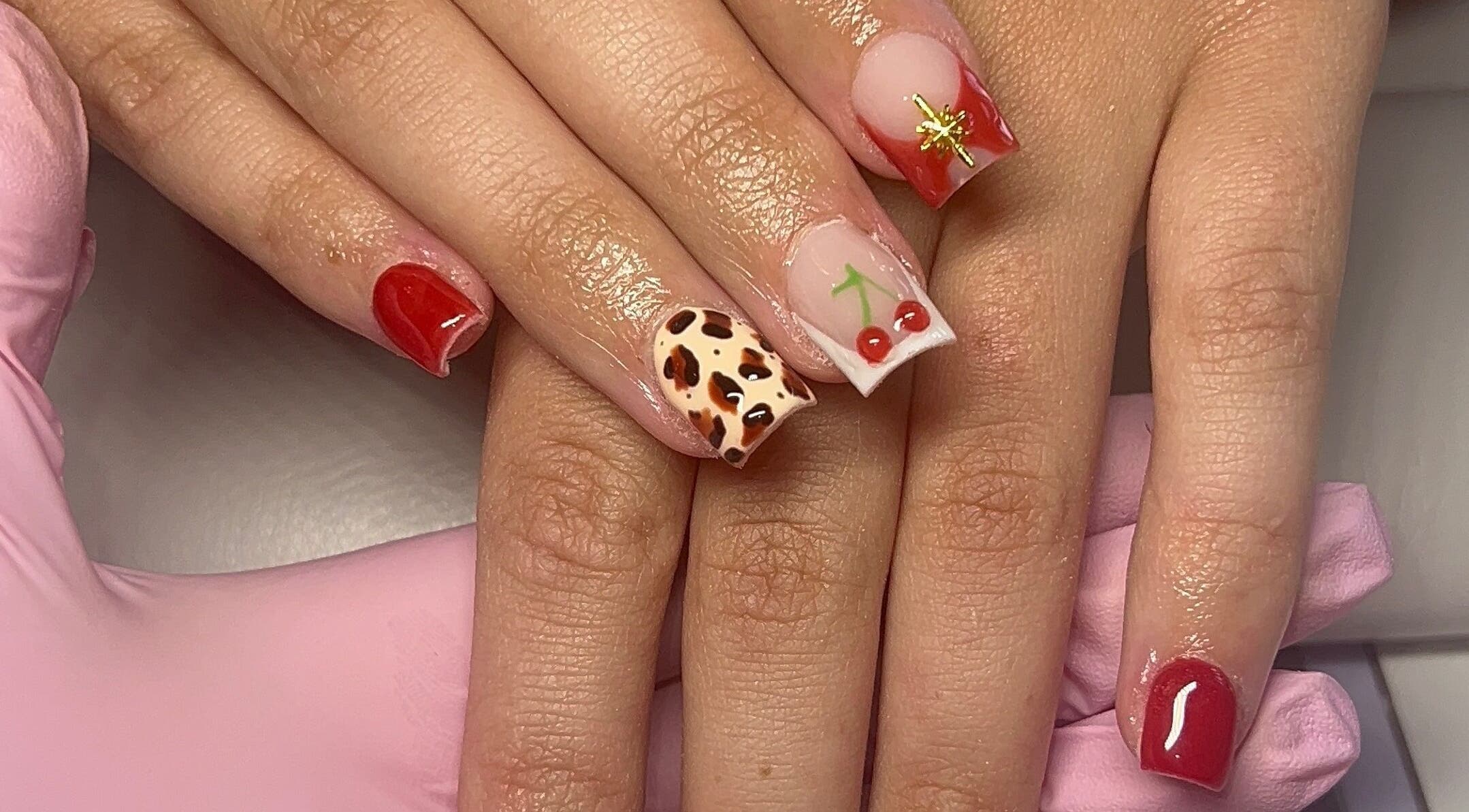 Stylish cherry and animal print nails by Beauty By Hannah in Moorside, England, GB.