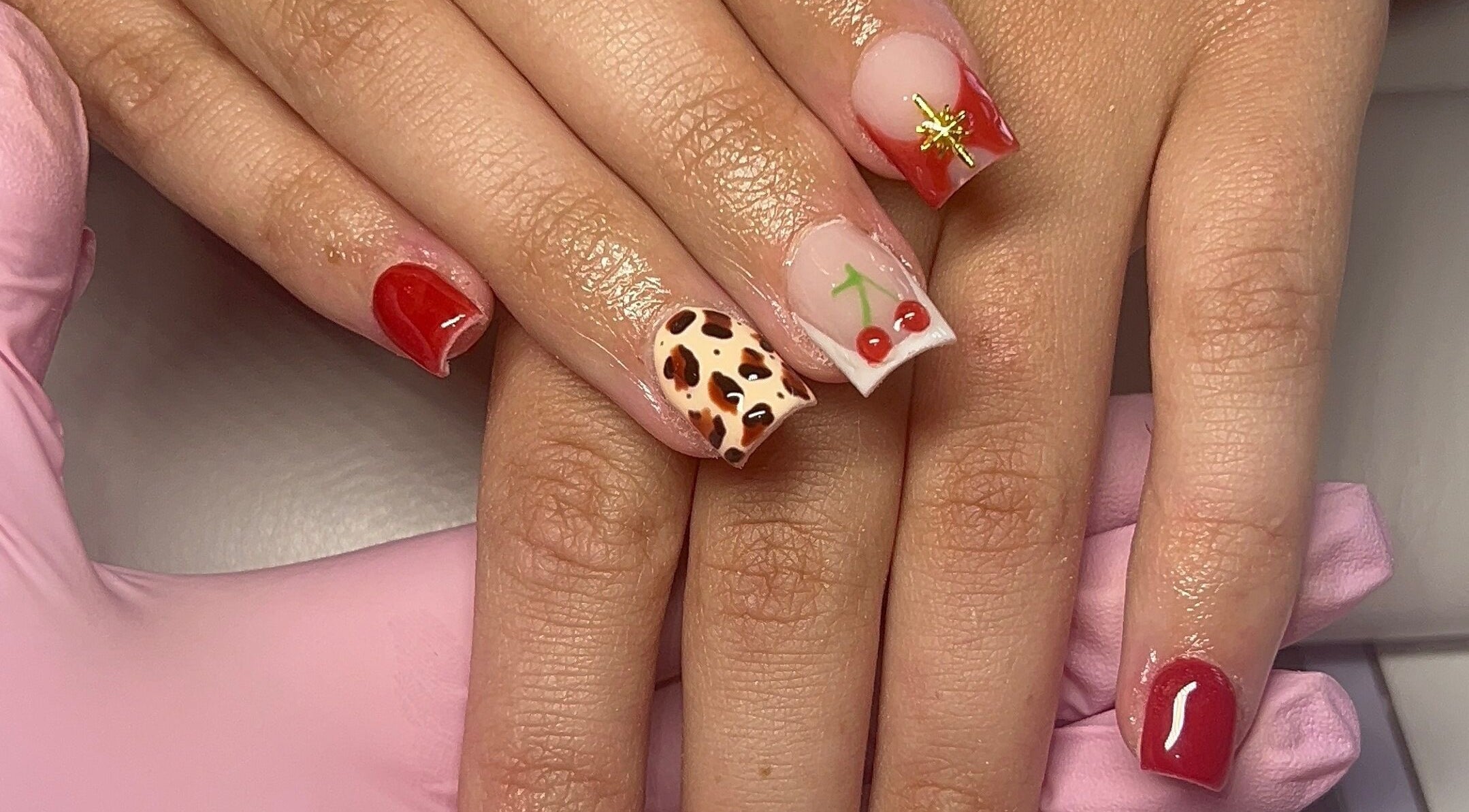 Stylish cherry and animal print nails by Beauty By Hannah in Moorside, England, GB.