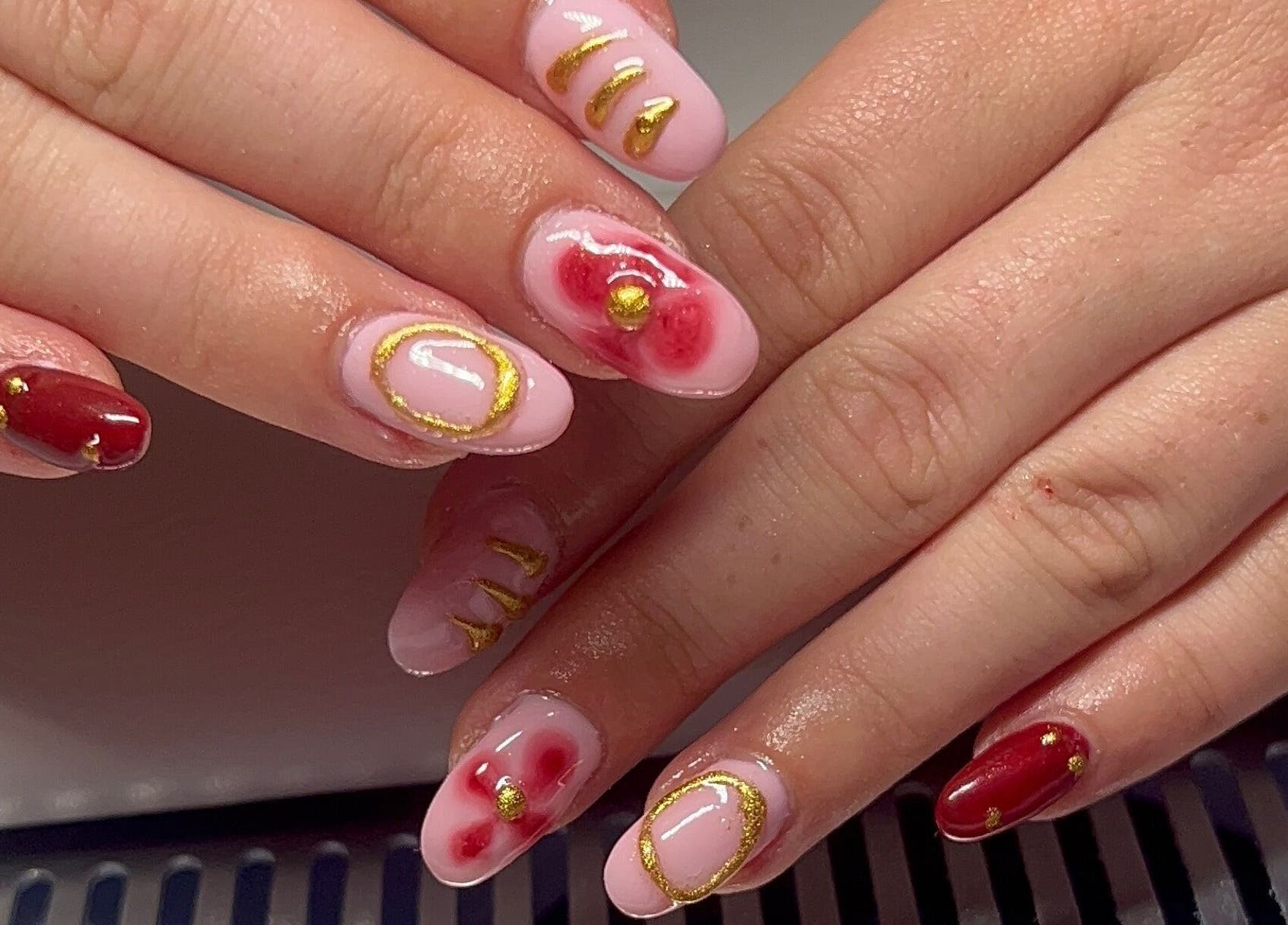 Stylish red and gold nail art at Beauty By Hannah, Moorside, England, GB.