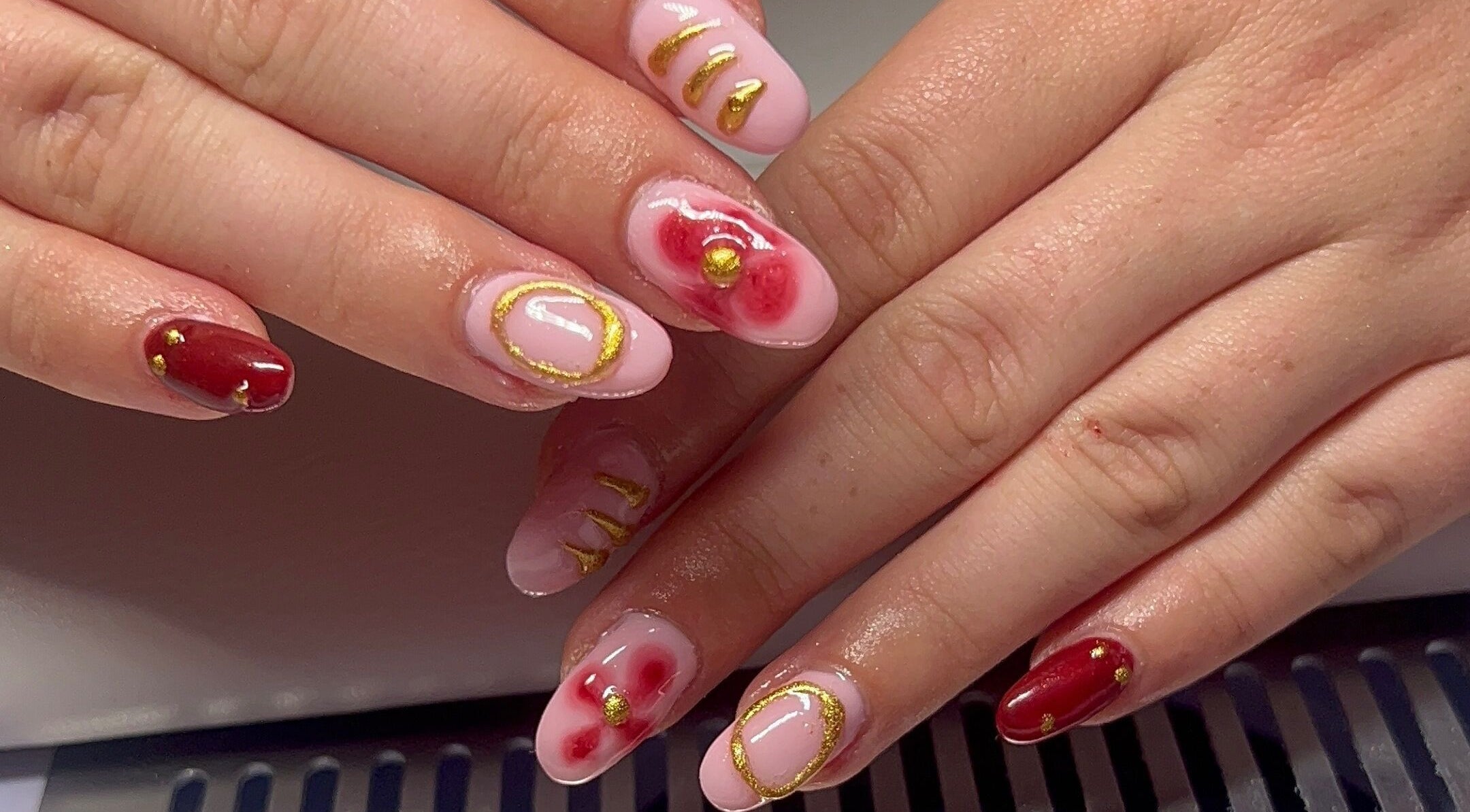 Stylish red and gold nail art at Beauty By Hannah, Moorside, England, GB.