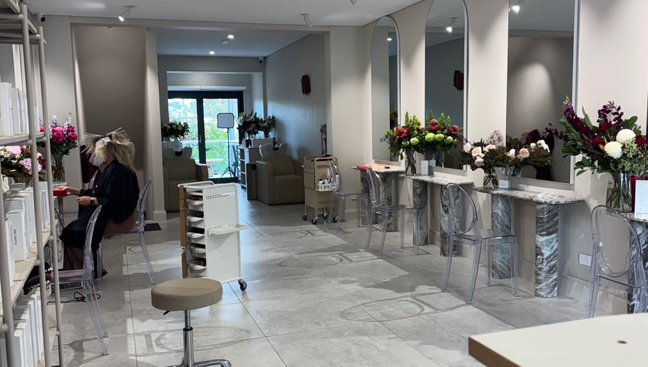 Interior of Giovanna Angela Hair in Birchgrove, NSW, AU, showcasing modern styling stations and floral decor.