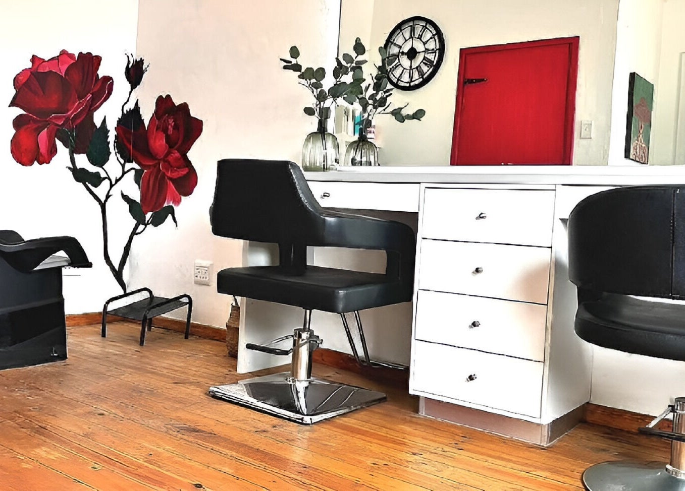 Stylish salon interior at Rum and Ruby Hair Design in Hermanus, Western Cape, ZA, featuring red rose mural.