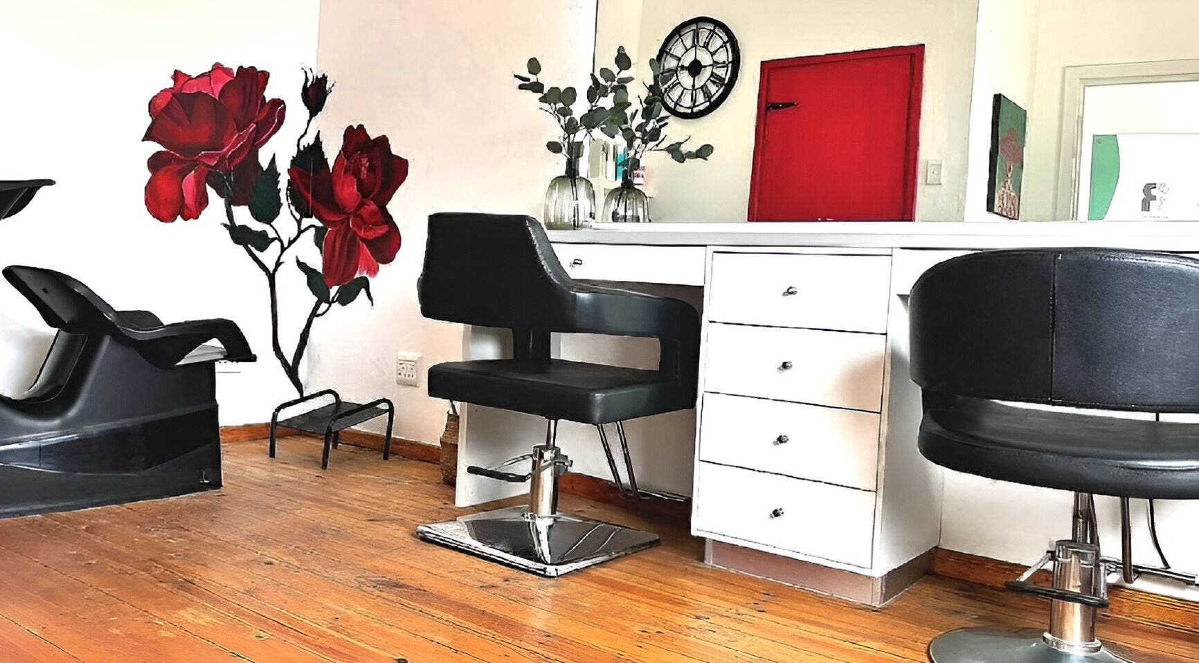 Stylish salon interior at Rum and Ruby Hair Design in Hermanus, Western Cape, ZA, featuring red rose mural.