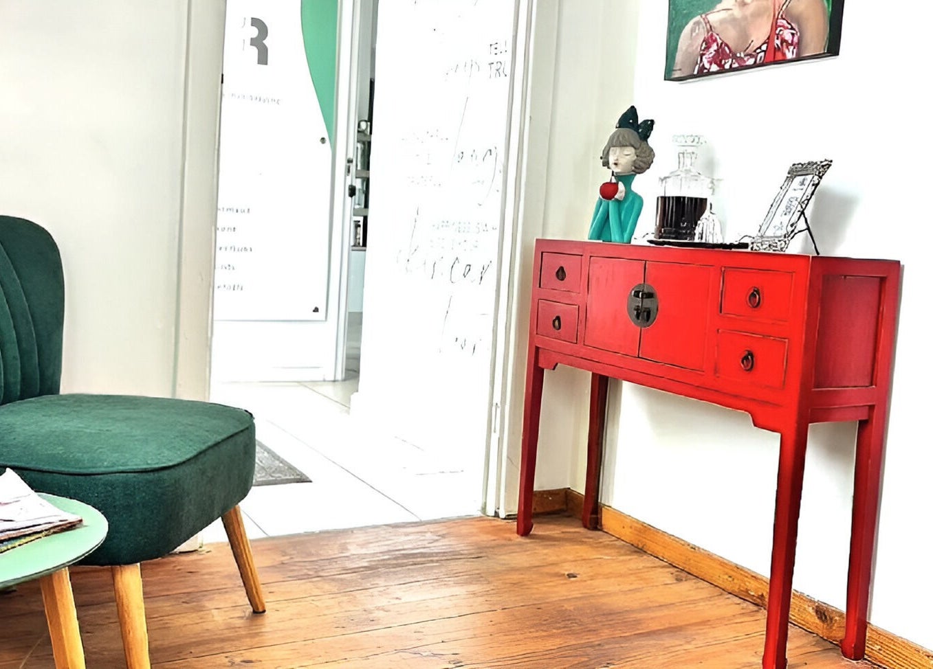 Cozy seating area at Rum and Ruby Hair Design, Hermanus, Western Cape, ZA with green chair and red console.