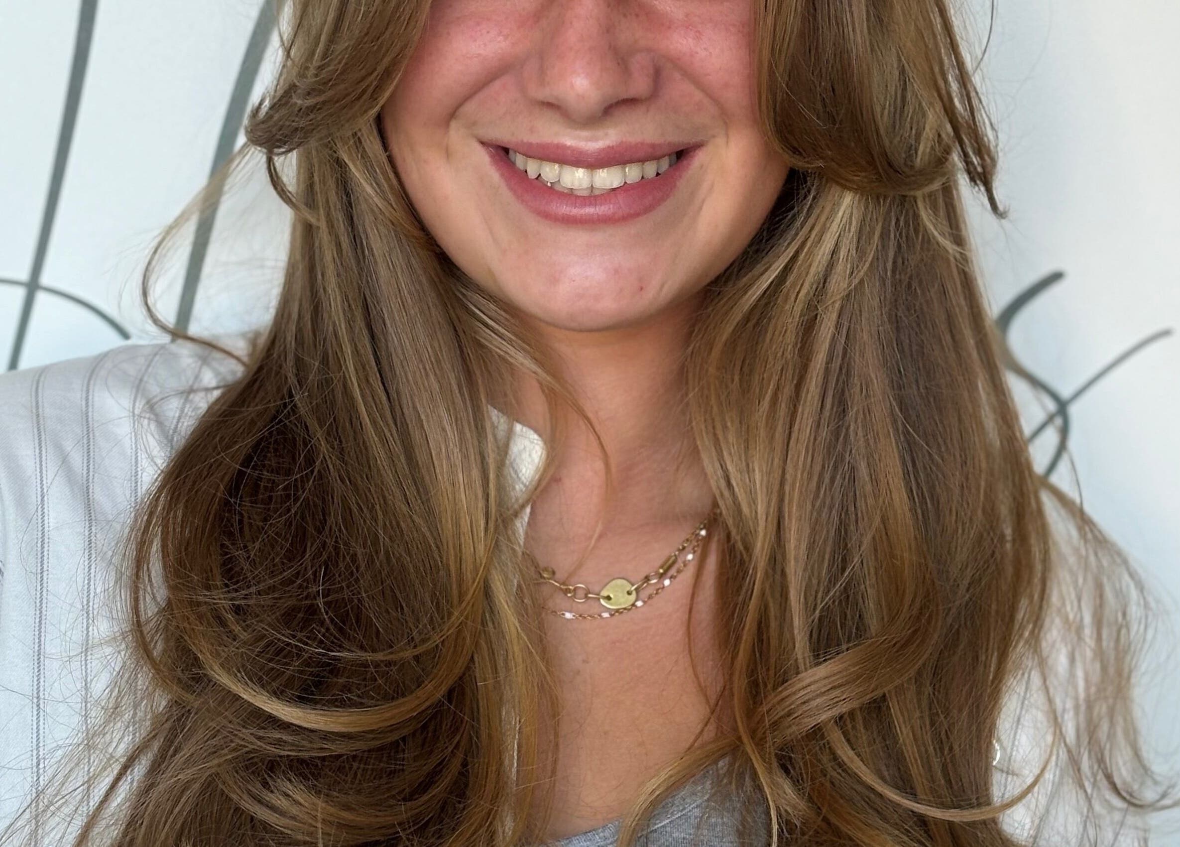 Smiling woman with golden brown hair at Rum and Ruby Hair Design, Hermanus, Western Cape, ZA.