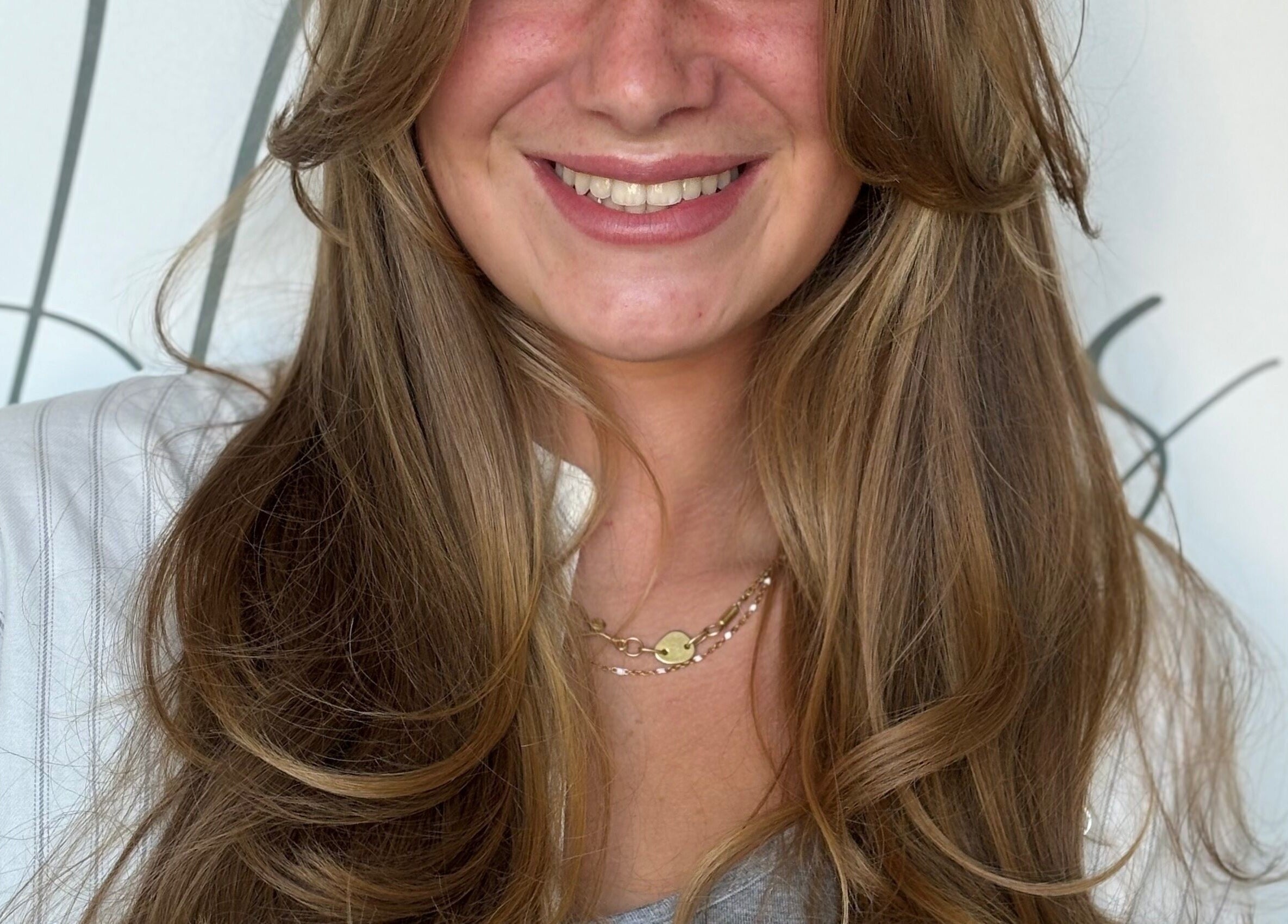 Smiling woman with golden brown hair at Rum and Ruby Hair Design, Hermanus, Western Cape, ZA.