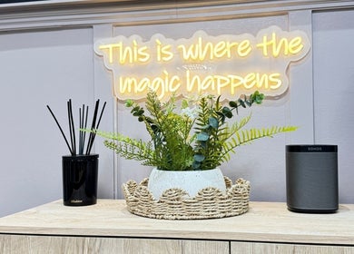 BN Beauty - Rottingdean showcases a serene decor with plants and a glowing 'magic happens' sign. Brighton And Hove, England, GB.