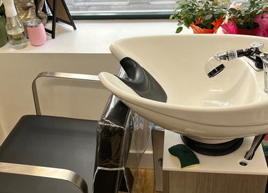 Modern shampoo station at Blowout Boulevard, New York, New York, US, with sleek chair and sink.