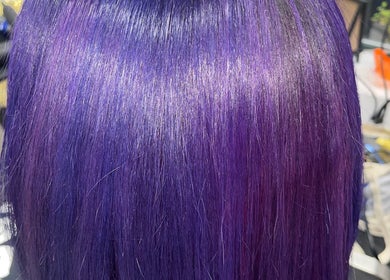 Vibrant violet hair styled at Blowout Boulevard, New York, New York, US. Smooth, glossy finish for a bold look.