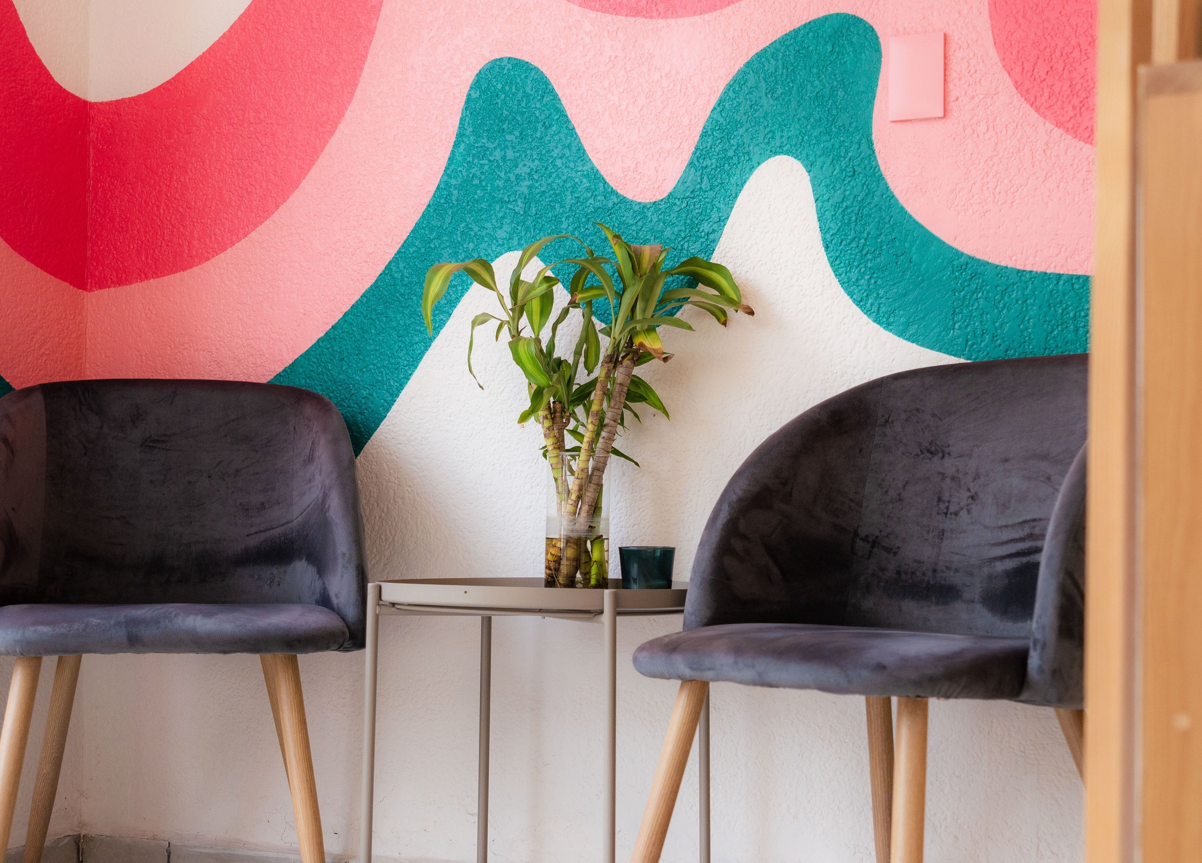 Acogedor rincón en Bloom! Estudio de uñas, Ciudad De México, con sillas y murales vibrantes.