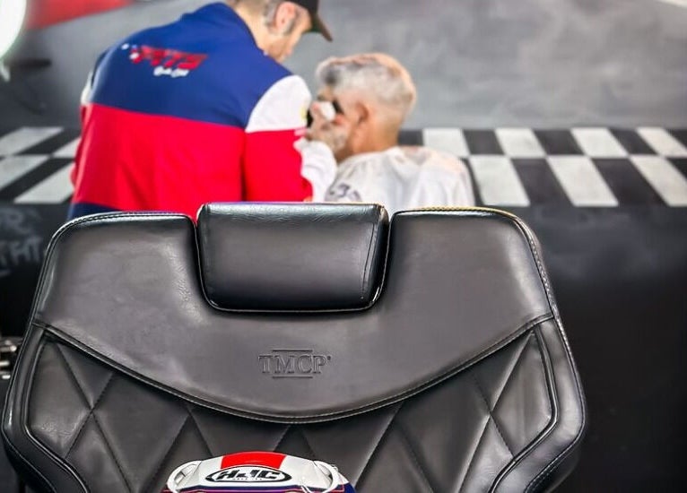 Barber chair at Pits Barber Club in Buenos Aires, Ciudad Autónoma De Buenos Aires, AR with stylist in background.
