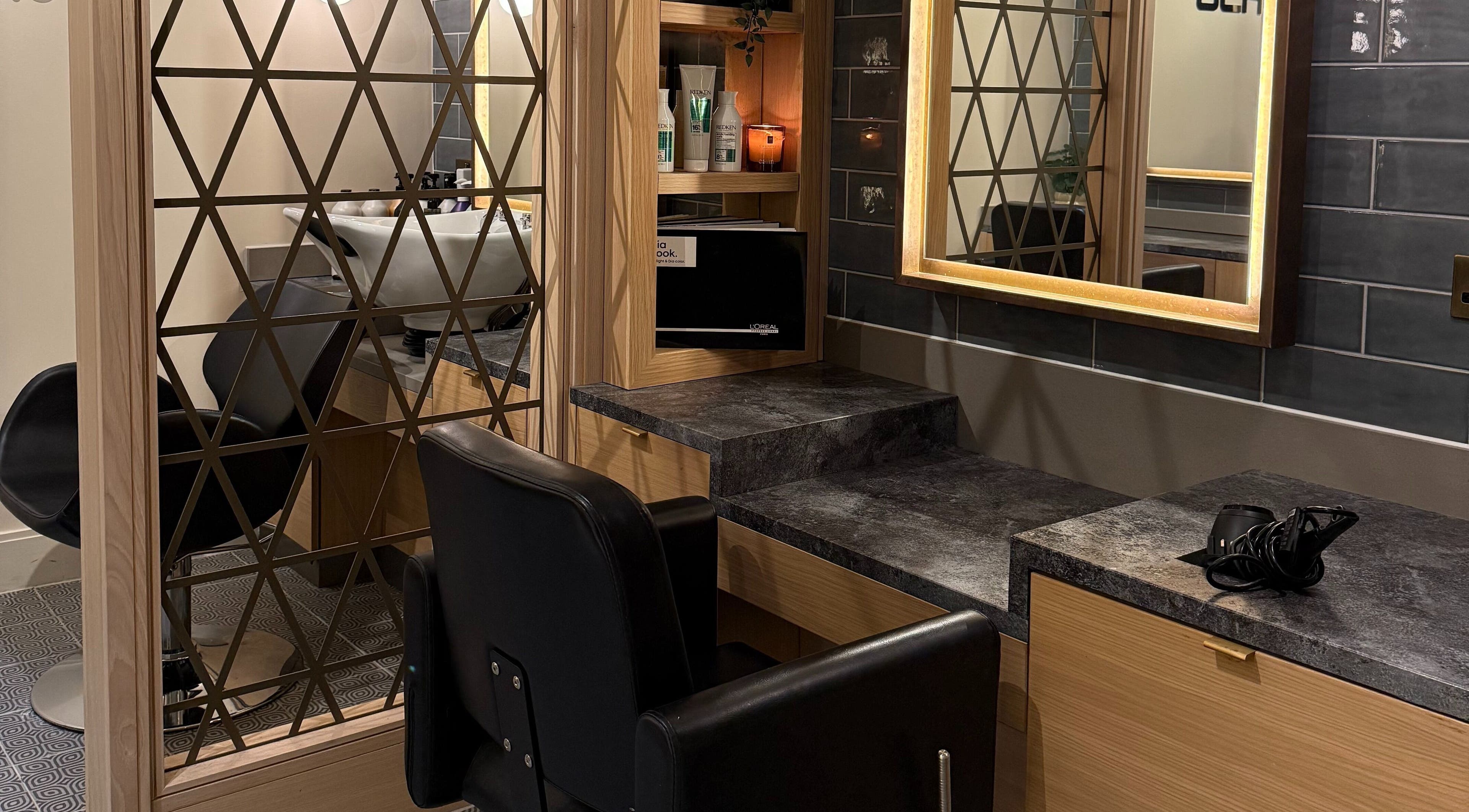 Stylish salon interior at GLAZED By JC in Mottram, England with modern mirrors and sleek styling stations.