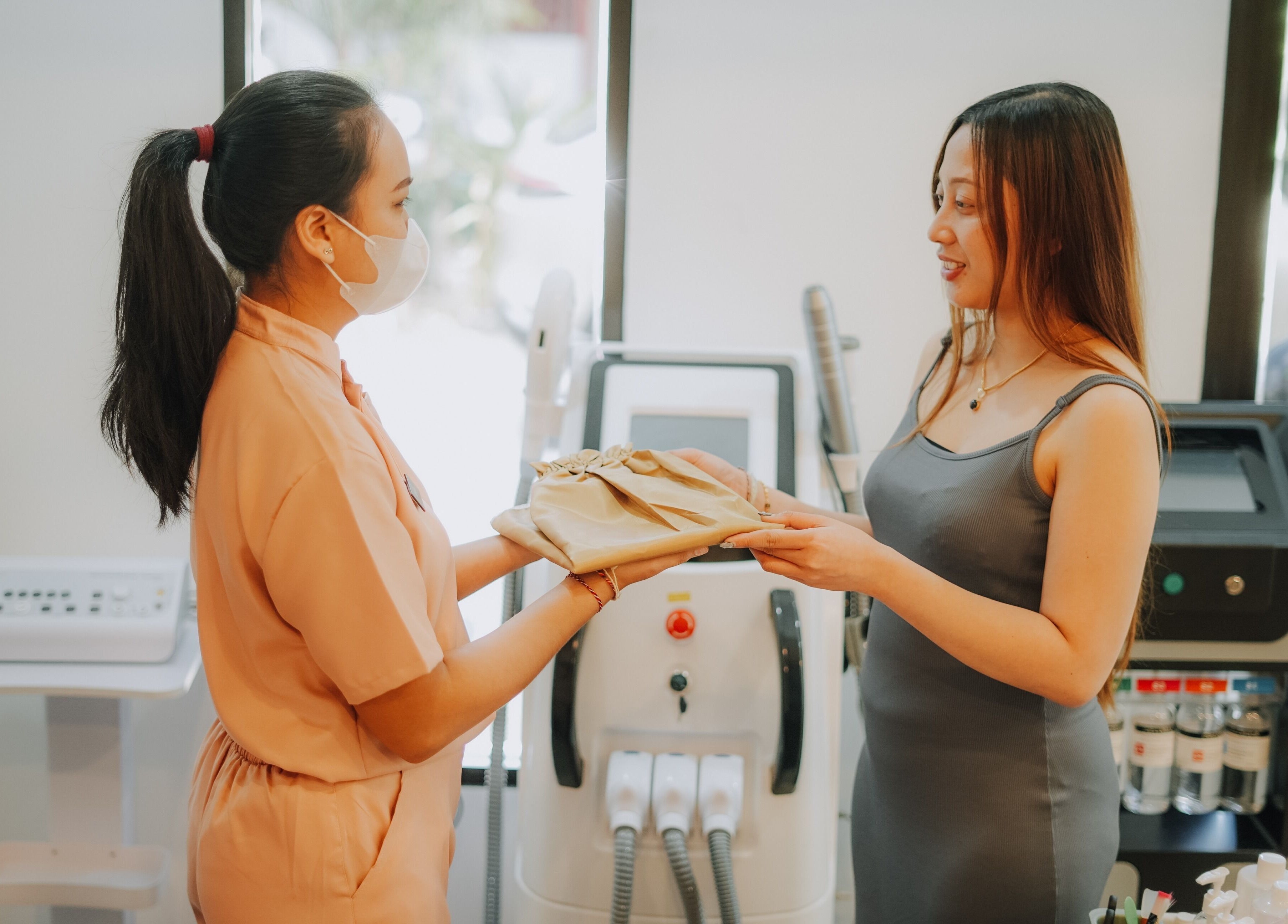Staff handing an item to a guest at Glow In Beauty Studio, Bali, Bali, ID, showcasing welcoming service.
