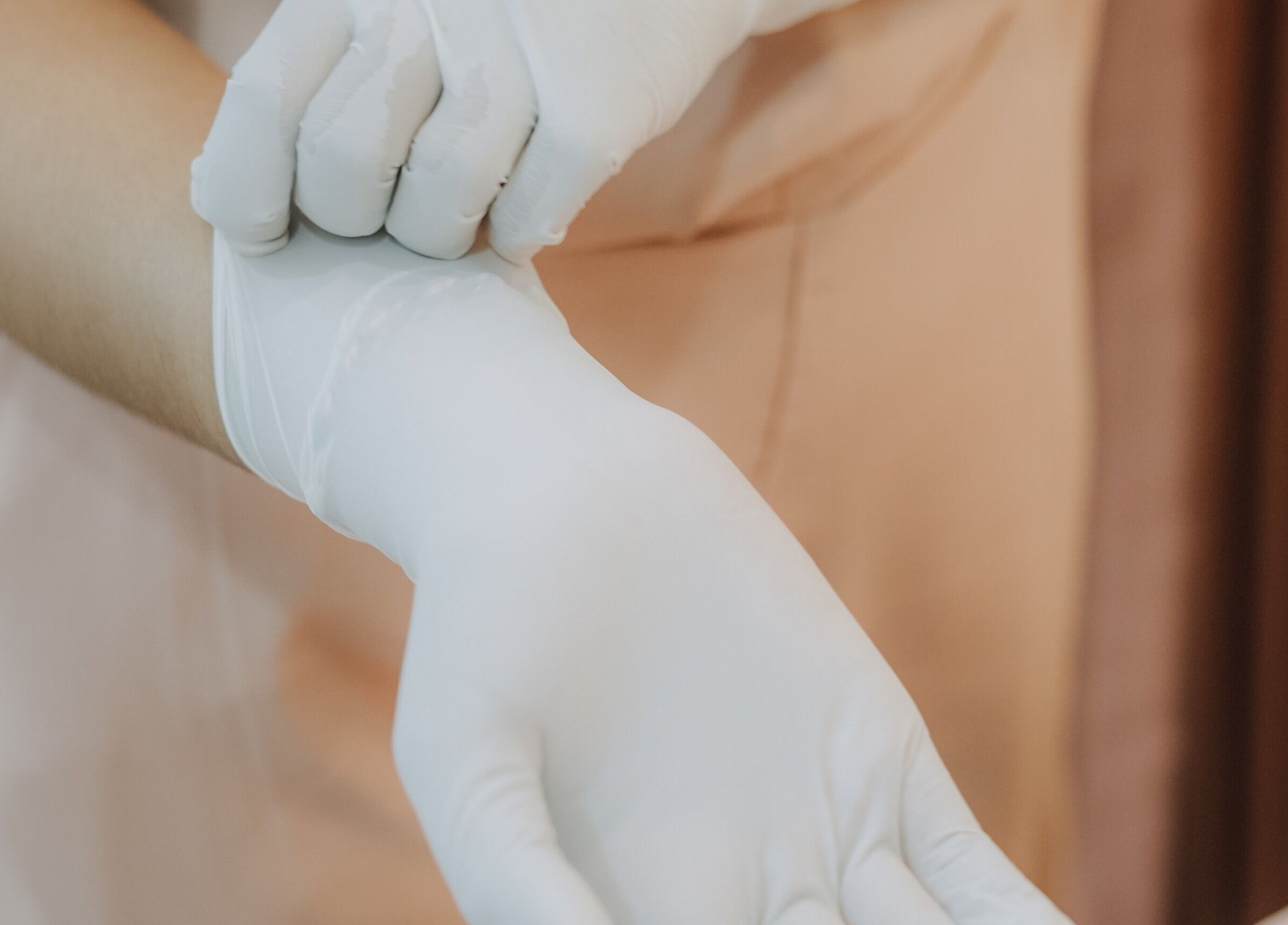 Technician at Glow In Beauty Studio Bali, Bali, ID, wearing white gloves for skincare treatment.