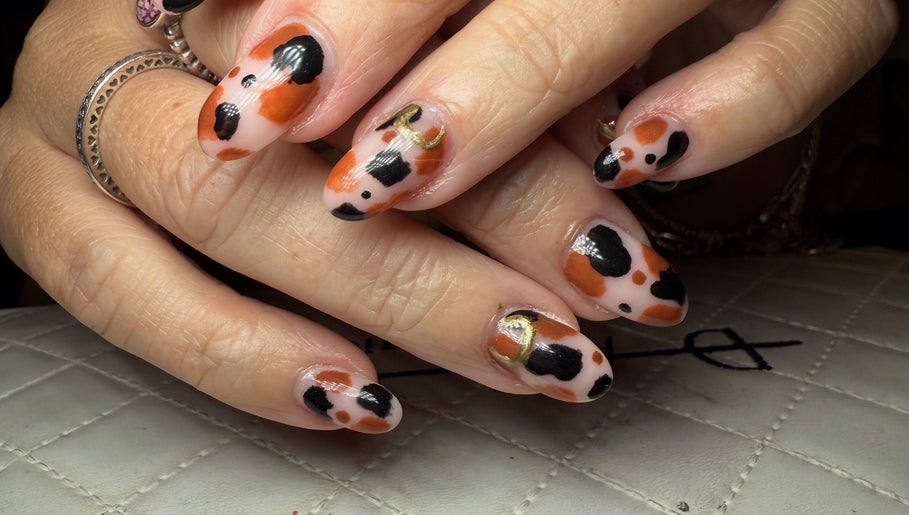 Stylish black and orange nail art at BySammieJo in Rainham, England, GB.