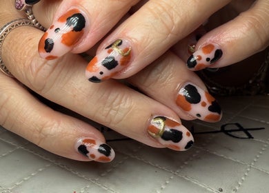 Stylish black and orange nail art at BySammieJo in Rainham, England, GB.