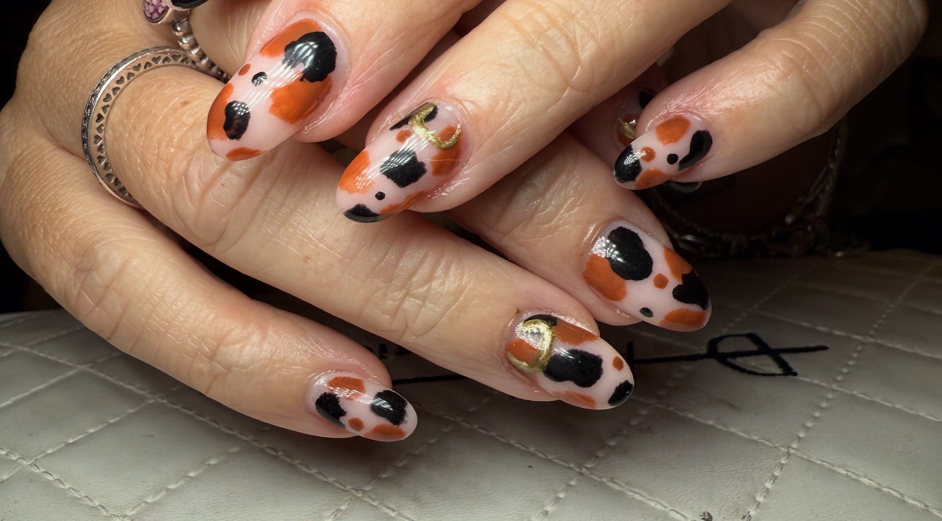 Stylish black and orange nail art at BySammieJo in Rainham, England, GB.