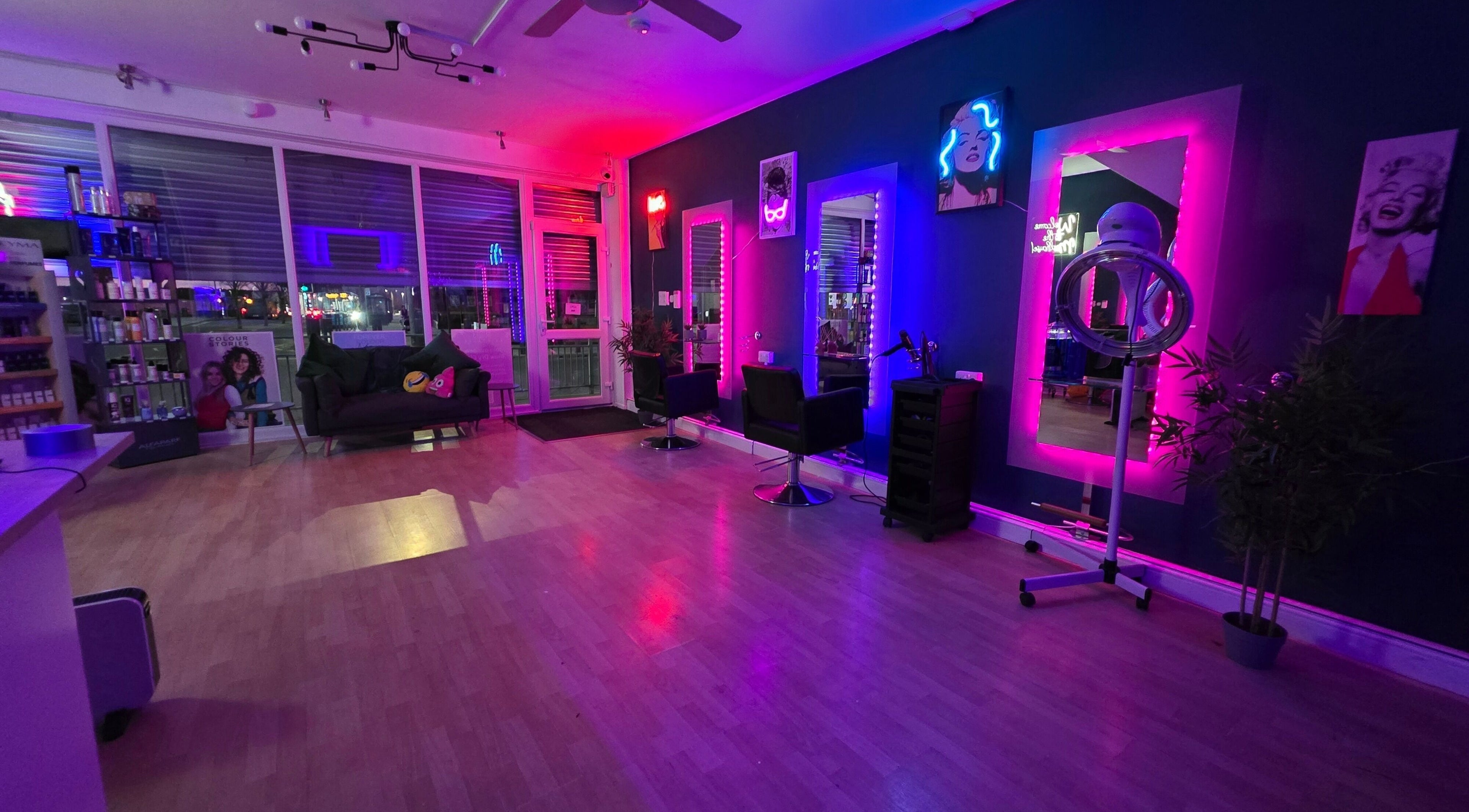 Modern interior of Jason's Hair Salon in Ashington with vibrant neon lighting and styling chairs.