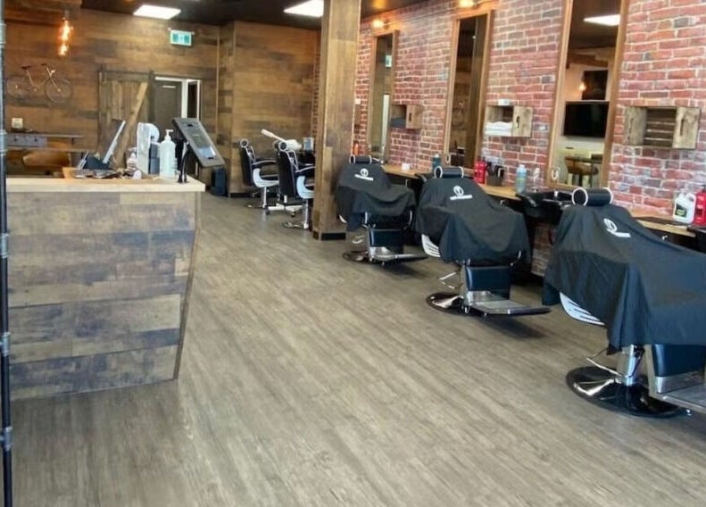 Interior of Mr. Barber Leduc in Leduc, Alberta, CA showcasing rustic barber chairs and modern decor.