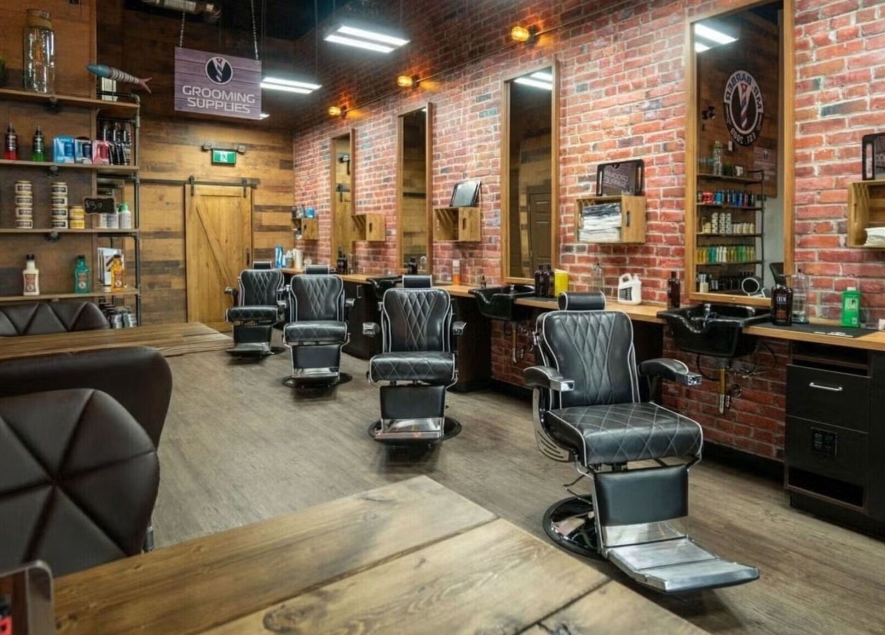 Modern barbershop interior at Mr. Barber Hamptons, Edmonton, Alberta, CA, featuring sleek leather chairs.