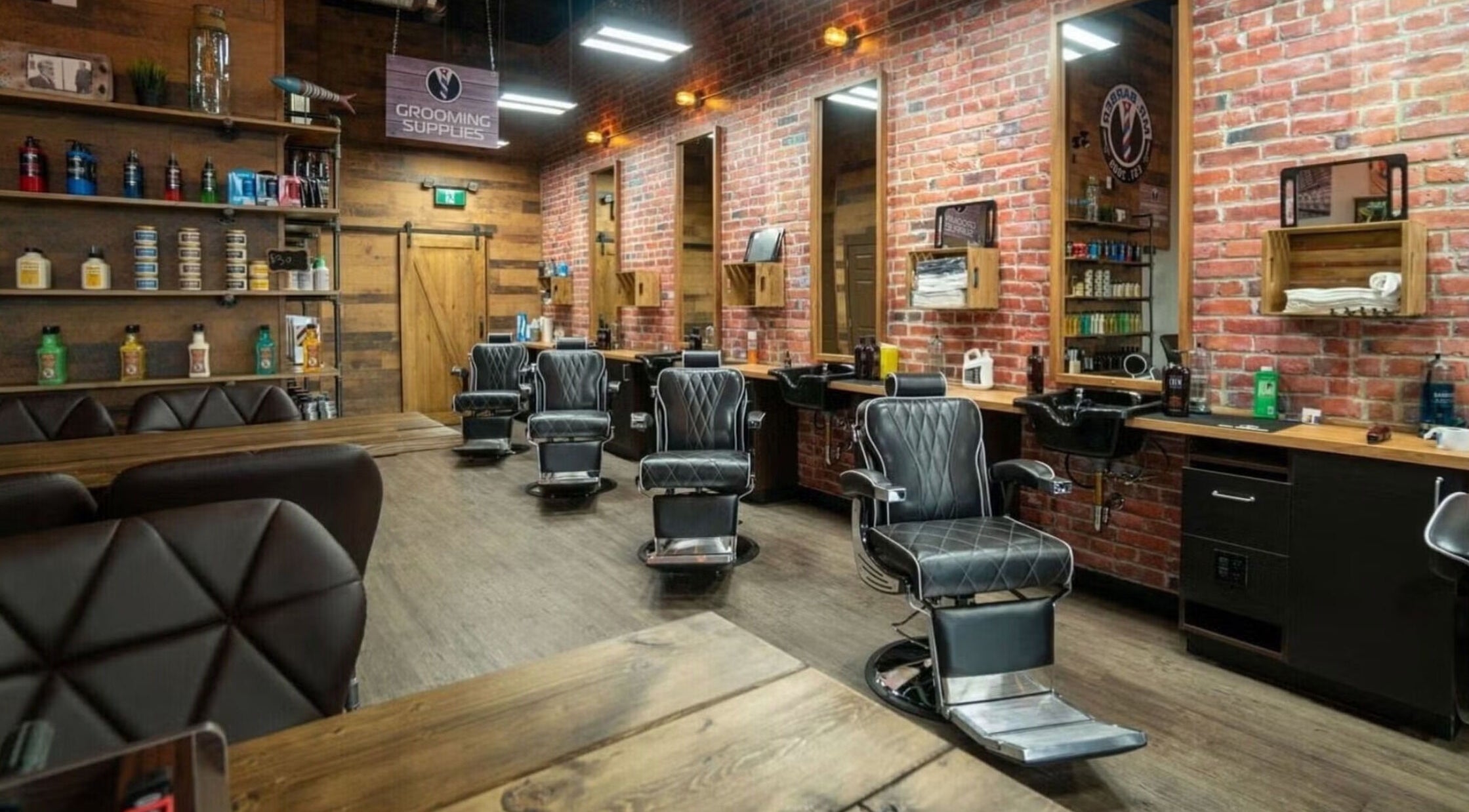 Modern barbershop interior at Mr. Barber Hamptons, Edmonton, Alberta, CA, featuring sleek leather chairs.
