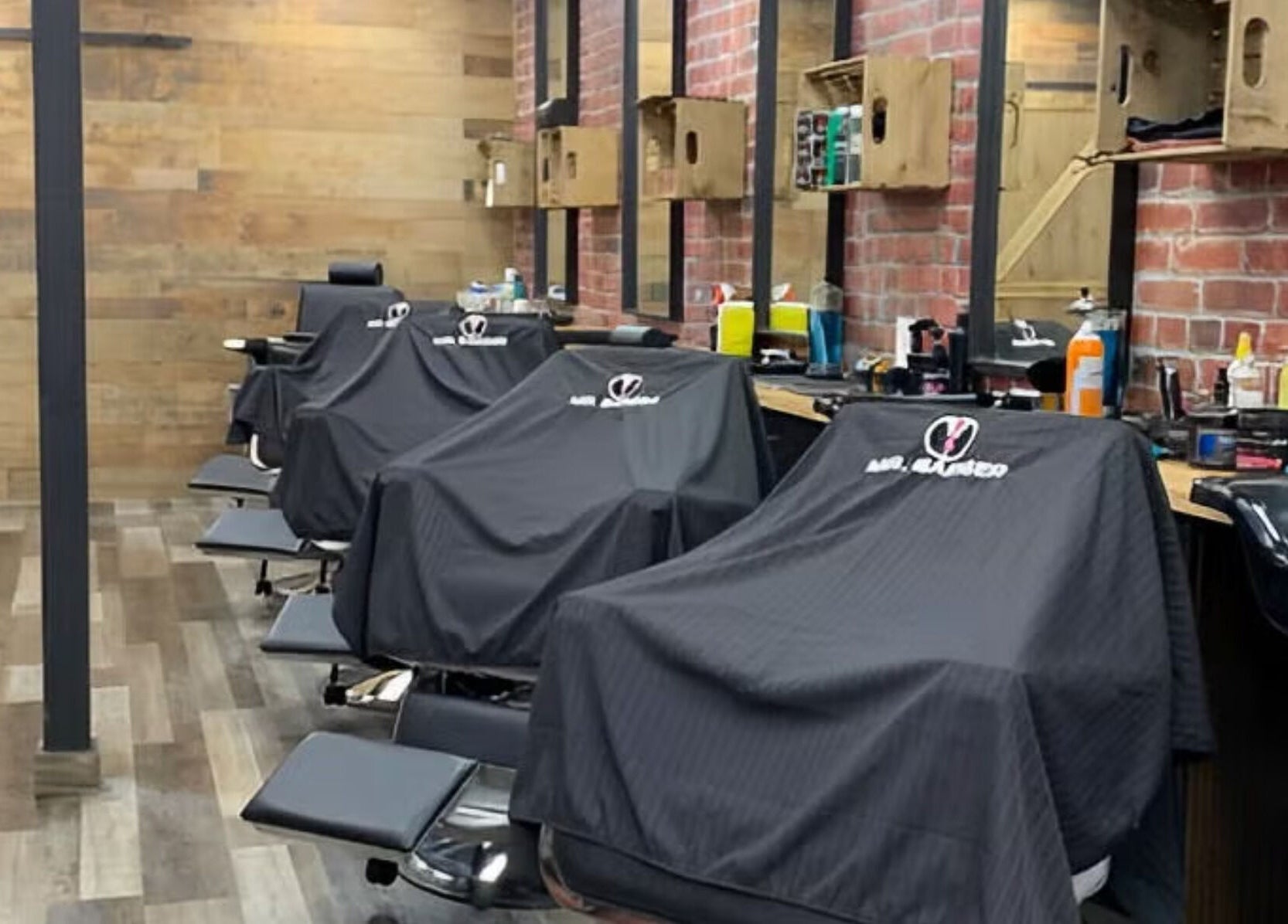 Interior view of Mr. Barber Hamptons, Edmonton, Alberta, CA with stylish barber chairs and exposed brick design.