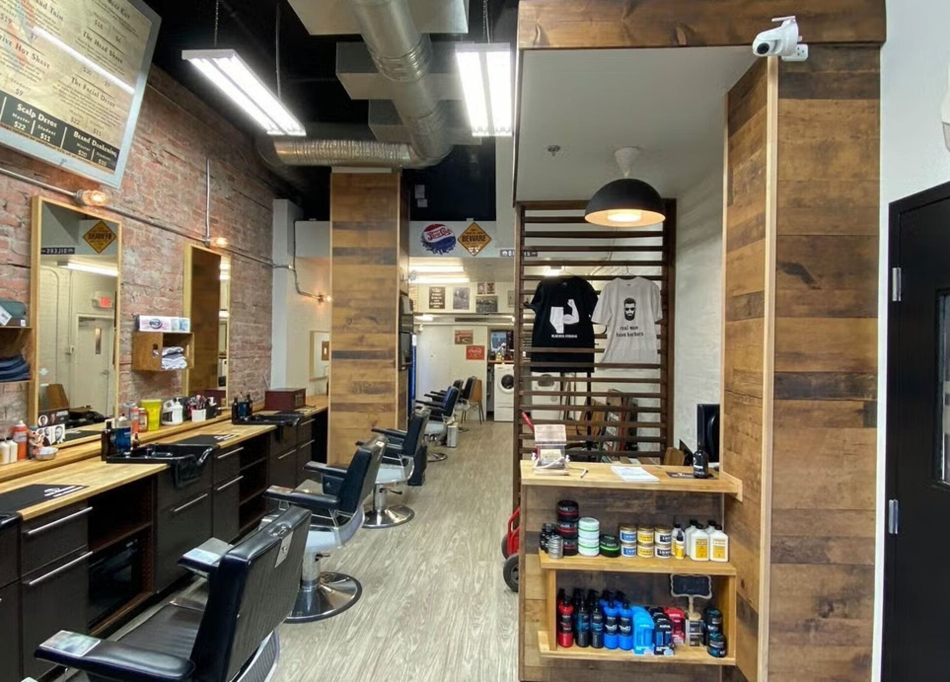 Modern interior of Mr. Barber Griesbach, Edmonton, Alberta, CA showcasing wooden decor and barber chairs.