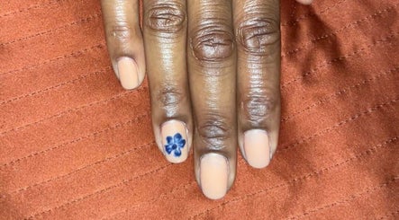 Manicure with floral accent nail by Nailphoria Beauty in Leeds, England, GB on orange fabric.
