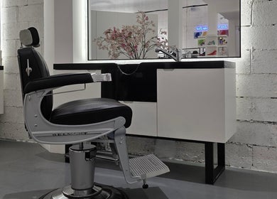 Modern barber chair in 8088 Barbershop - Avant Garde, Dubai, AE, with sleek black and silver design.