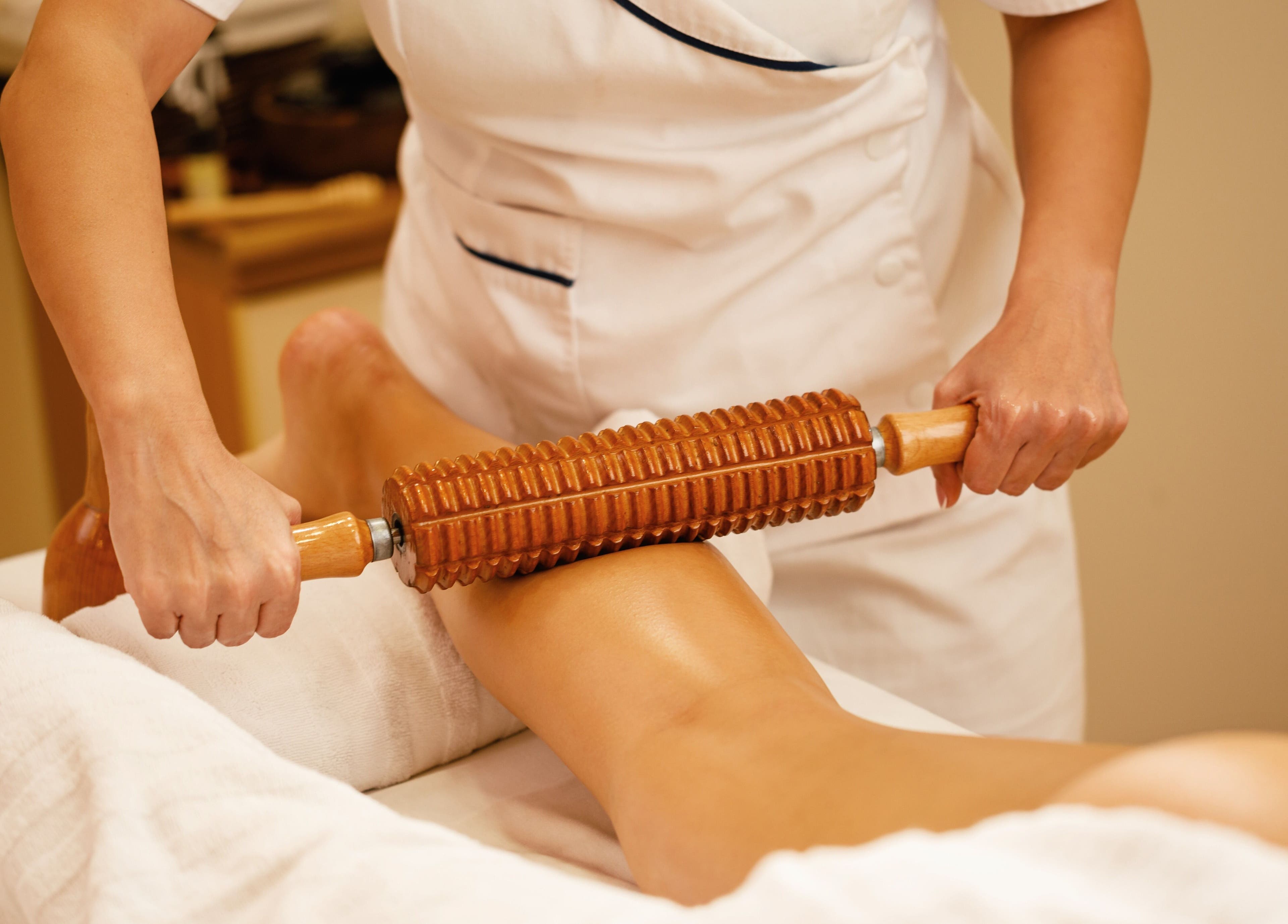 Thérapeute utilisant un rouleau en bois au W CARE CENTER à Chevry-cossigny, Île-de-france, FR.