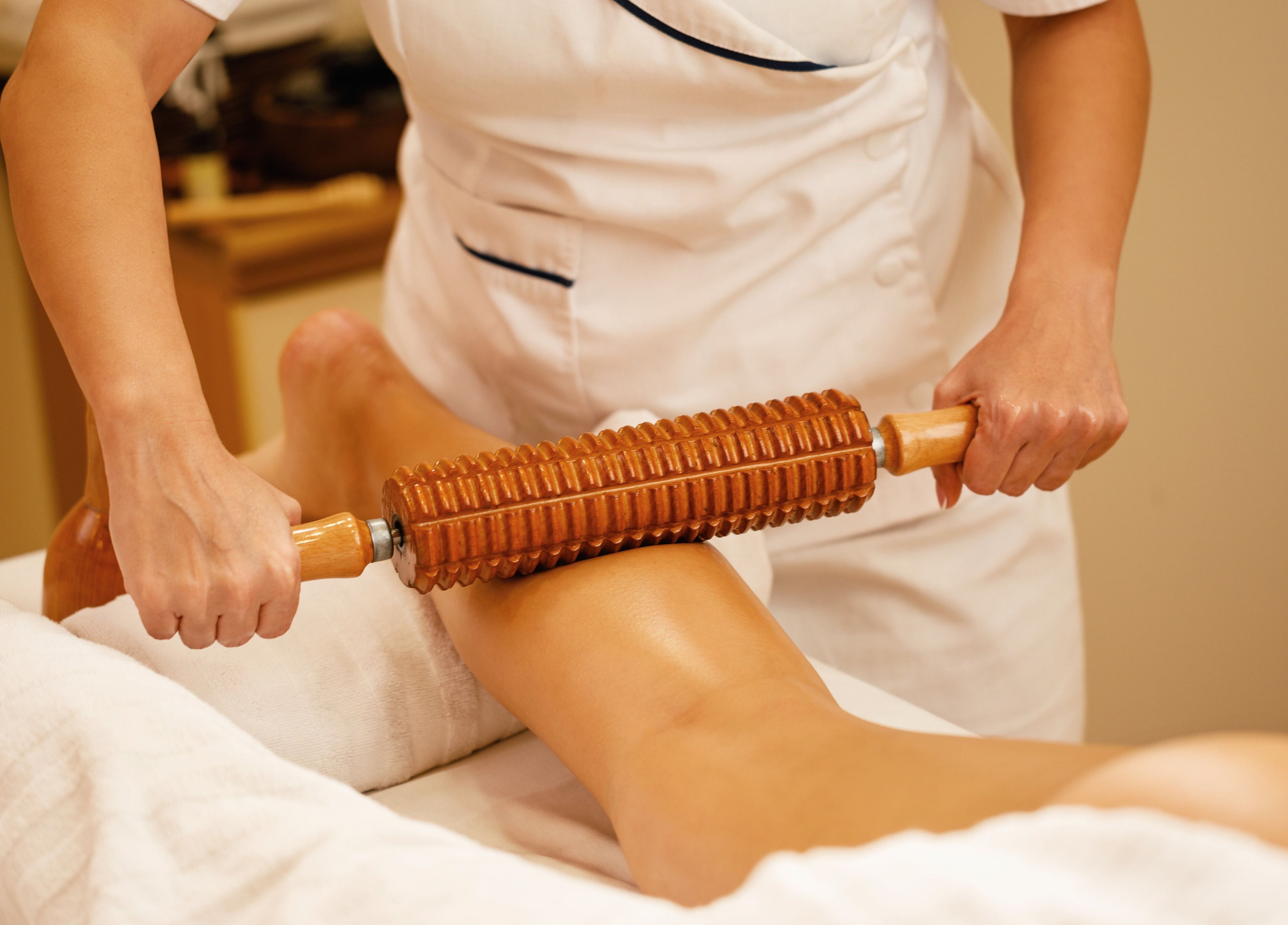 Thérapeute utilisant un rouleau en bois au W CARE CENTER à Chevry-cossigny, Île-de-france, FR.