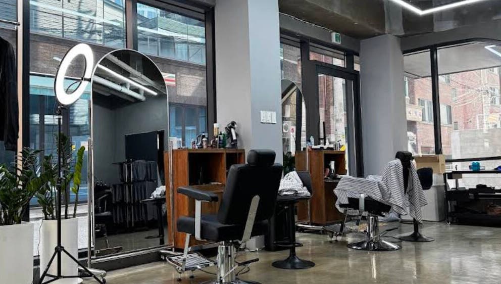 Modern salon interior at Korner Seoul, Seoul, 서울특별시, KR with sleek styling stations and large mirrors.