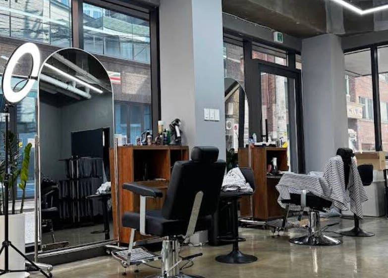 Modern salon interior at Korner Seoul, Seoul, 서울특별시, KR with sleek styling stations and large mirrors.