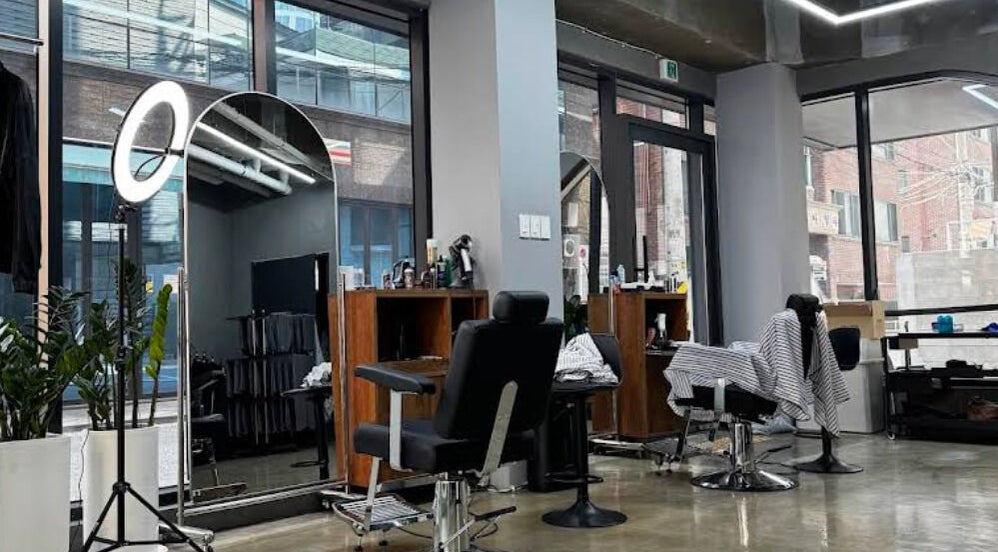 Modern salon interior at Korner Seoul, Seoul, 서울특별시, KR with sleek styling stations and large mirrors.