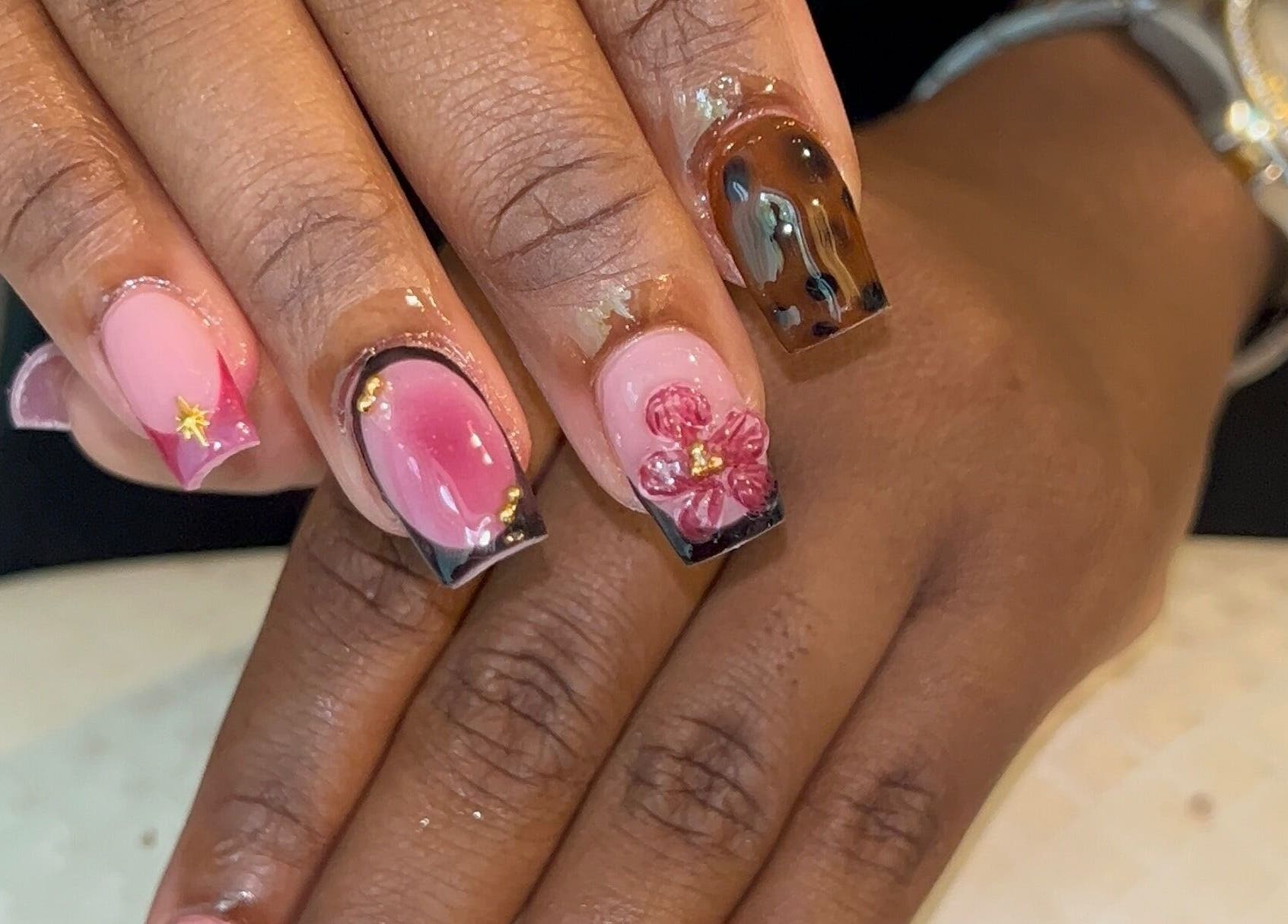 Intricate floral nail art at Nailzbyshaeimani, Kingston, St. Andrew Parish, JM featuring pink and brown designs.